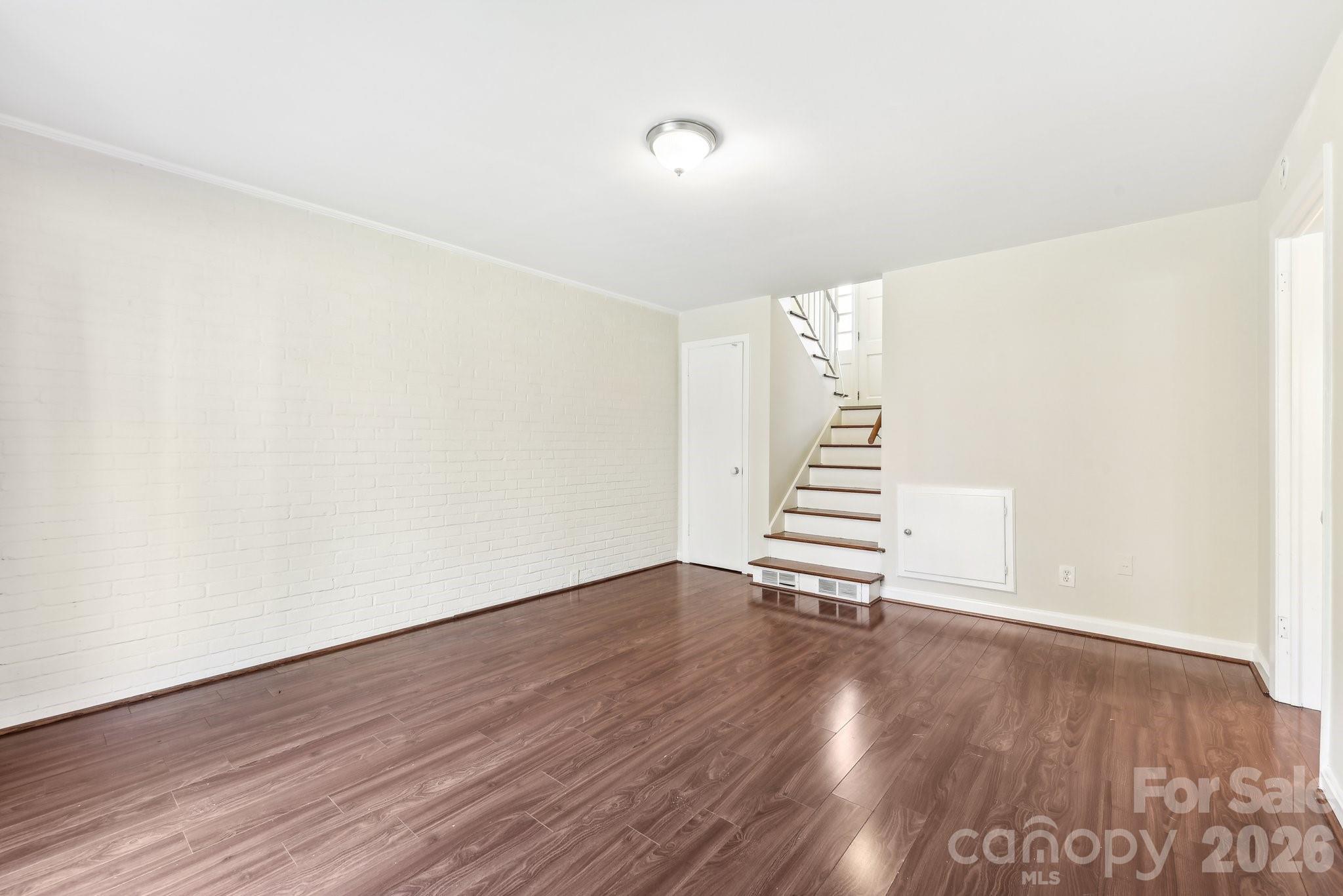 1334 Briar Creek Road, Unit 2 Charlotte, NC 28205 - Photo 19 of 30 a view of an empty room with wooden floor and stairs
