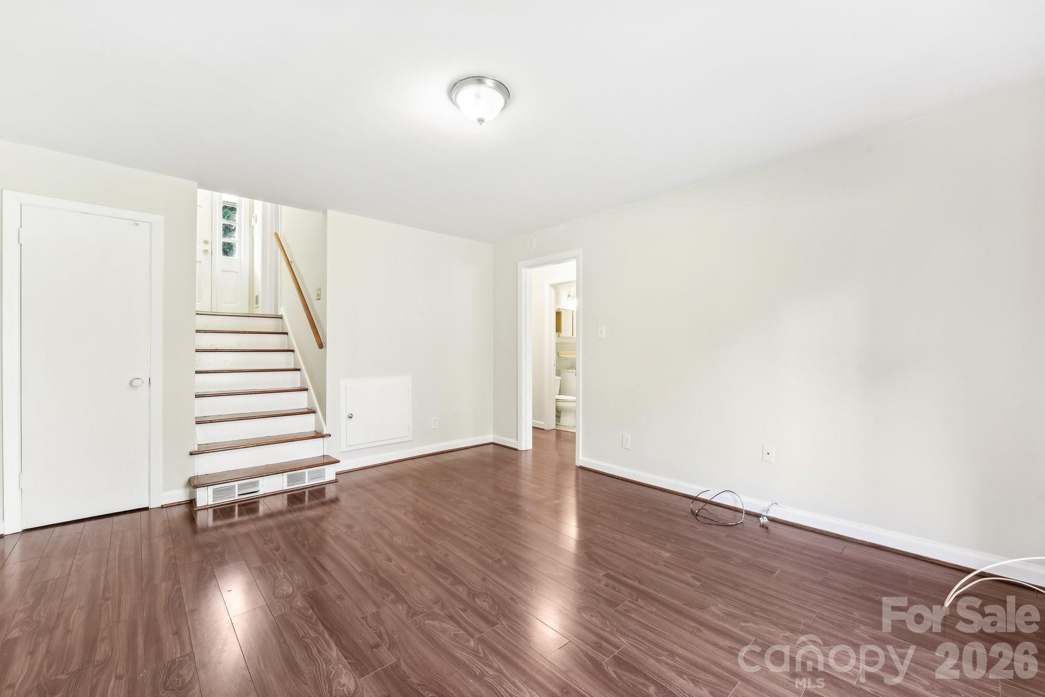 1334 Briar Creek Road, Unit 2 Charlotte, NC 28205 - Photo 4 of 30 a view of an empty room with wooden floor and stairs