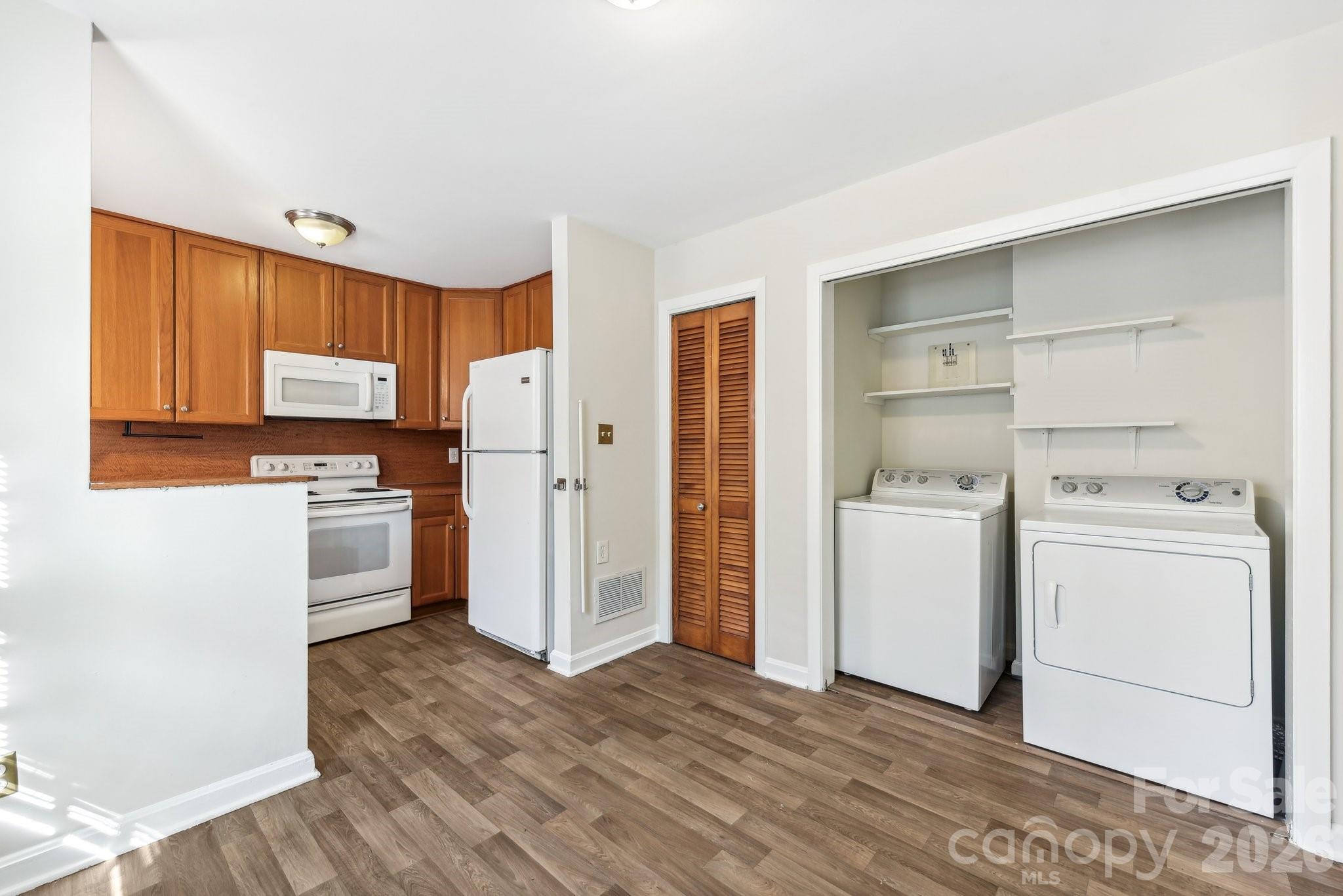 1334 Briar Creek Road, Unit 2 Charlotte, NC 28205 - Photo 5 of 30 a kitchen with a refrigerator stove and white cabinets