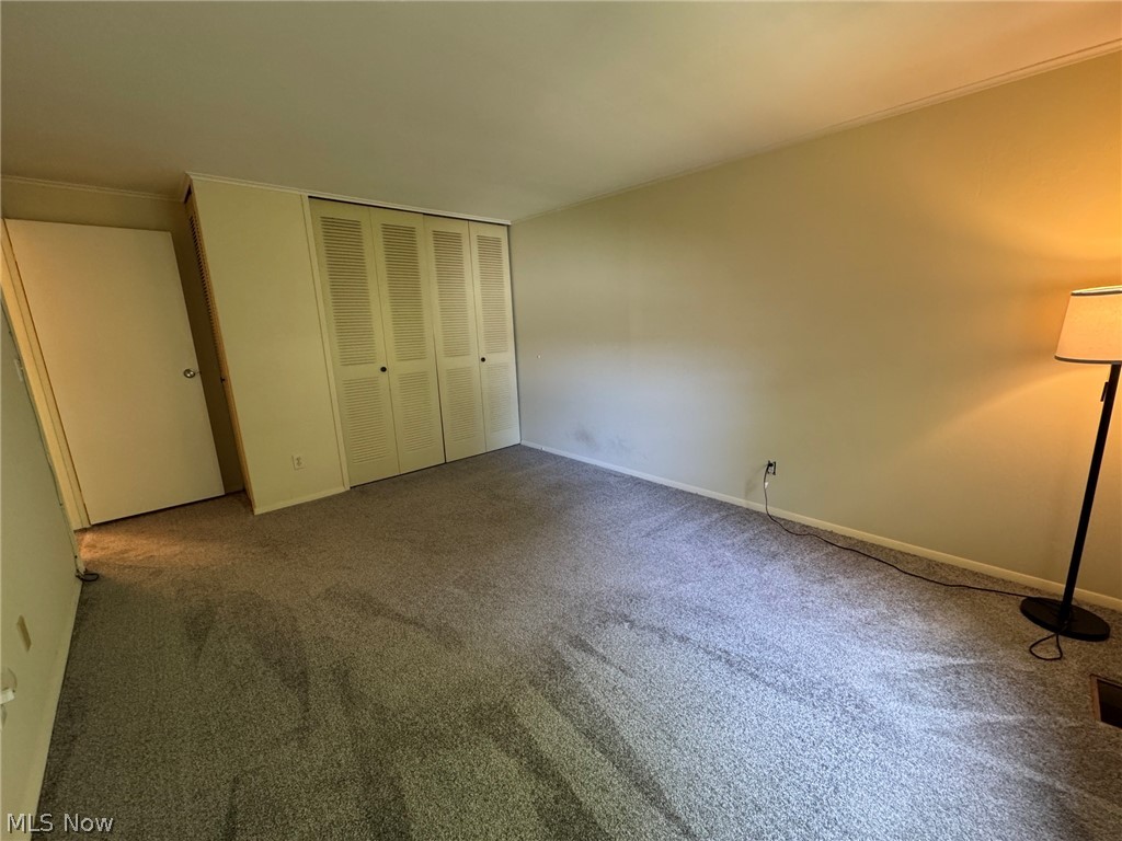 7294 Fox Mill Road, Unit 19D Mentor, OH 44060 - Photo 18 of 27 Carpeted room featuring neutral-toned walls, a white interior door, and a built-in closet with louvered bi-fold doors