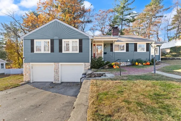 a front view of a house with a yard and a garden