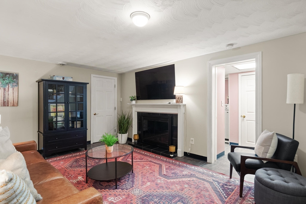 40 Friend Street Wakefield, MA 01880 - Photo 24 of 34 a living room with furniture a flat screen tv and a fireplace