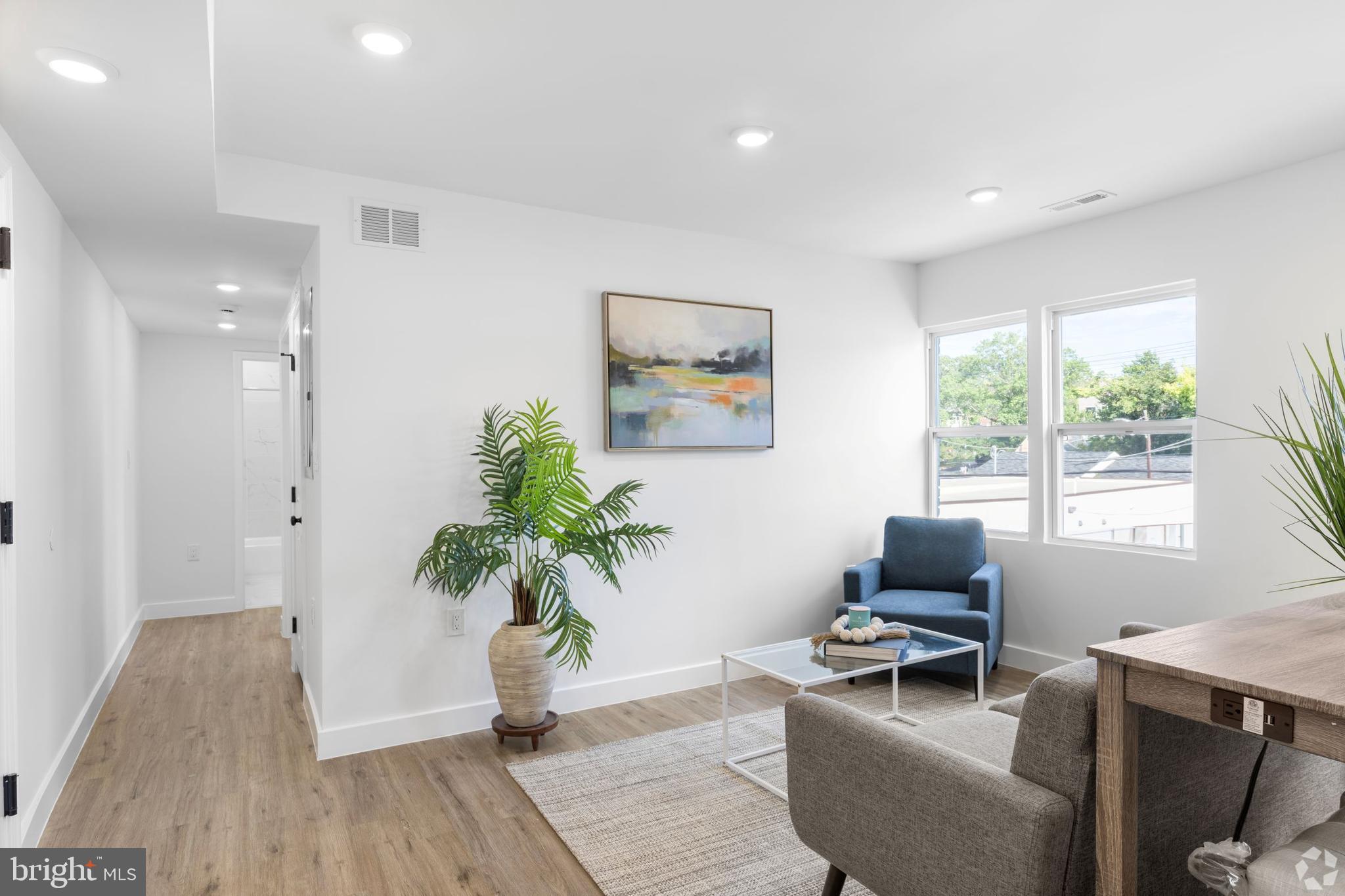 a living room with furniture a window and a potted plant