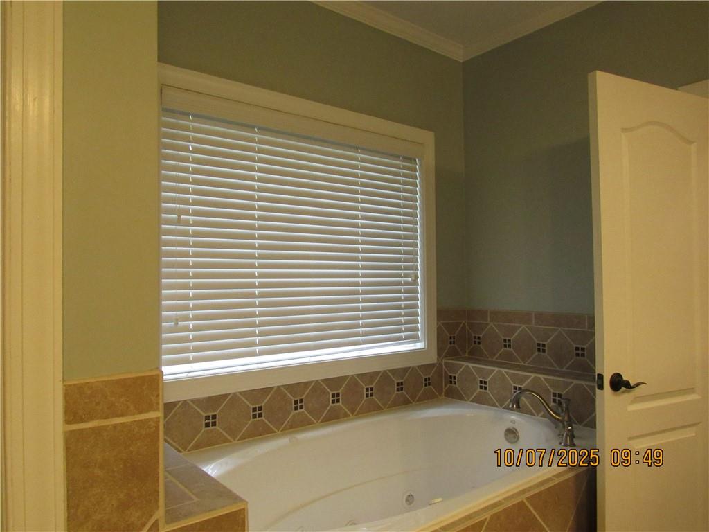 815 Spring View Court Covington, GA 30014 - Photo 13 of 43 a bath tub sitting in a bathroom next to a window