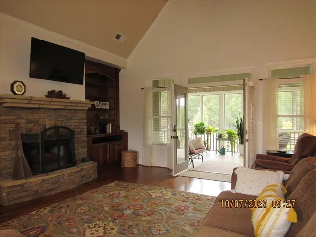 a living room with furniture a flat screen tv and a fireplace