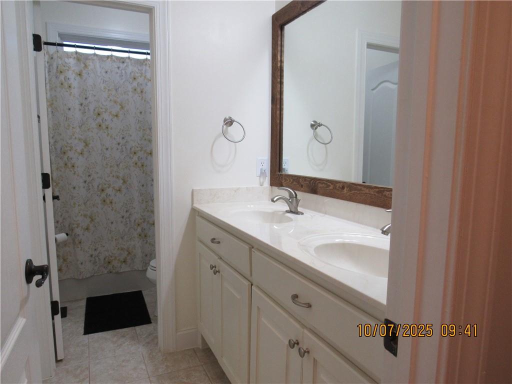 815 Spring View Court Covington, GA 30014 - Photo 22 of 43 a bathroom with a double vanity sink a toilet and a mirror