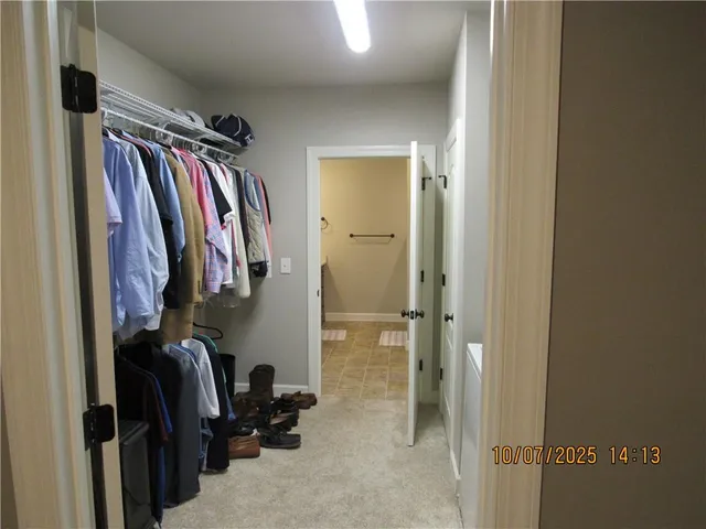a view of walk in closet with clothes and shoes