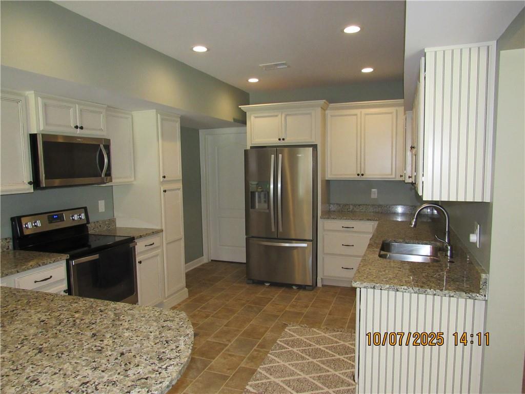 815 Spring View Court Covington, GA 30014 - Photo 35 of 43 a kitchen with stainless steel appliances granite countertop a refrigerator a stove a sink and a microwave