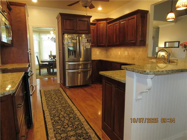 a kitchen with granite countertop stainless steel appliances and wooden cabinets