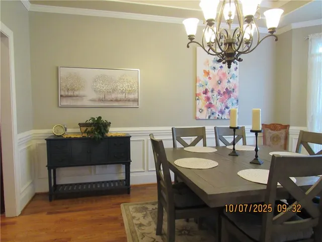 a view of a dining room with furniture and chandelier