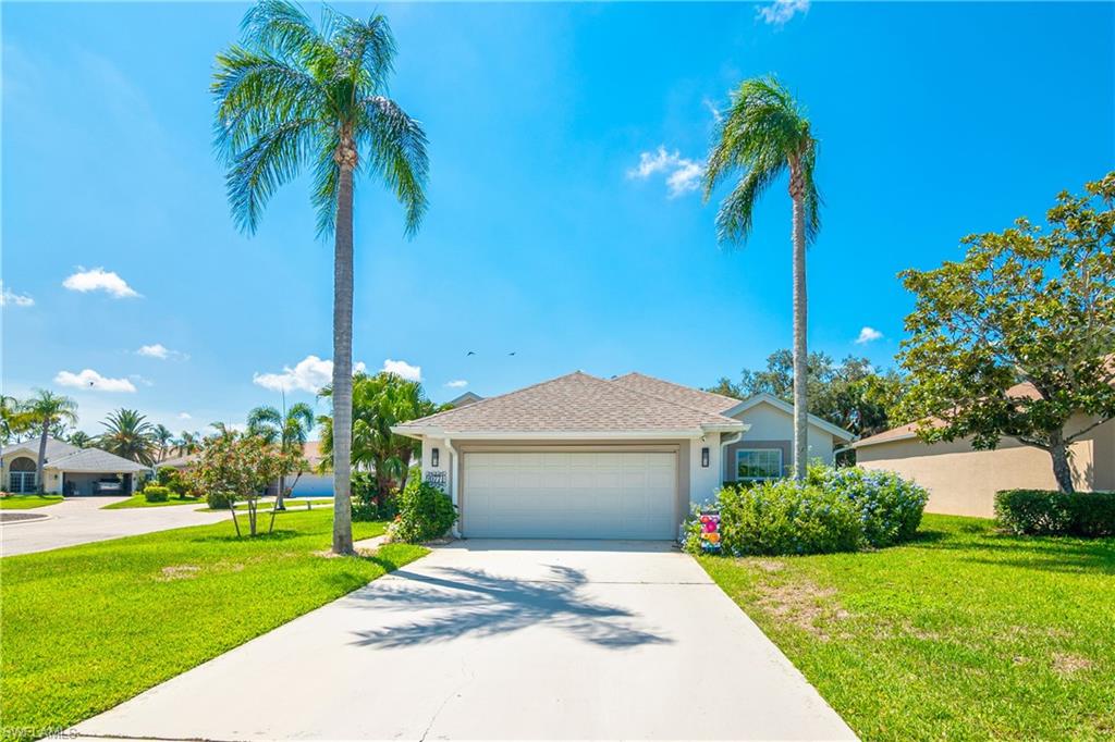 20771 Persimmon Place Estero, FL 33928 - Photo 30 of 50 a front view of a house with a garden and trees