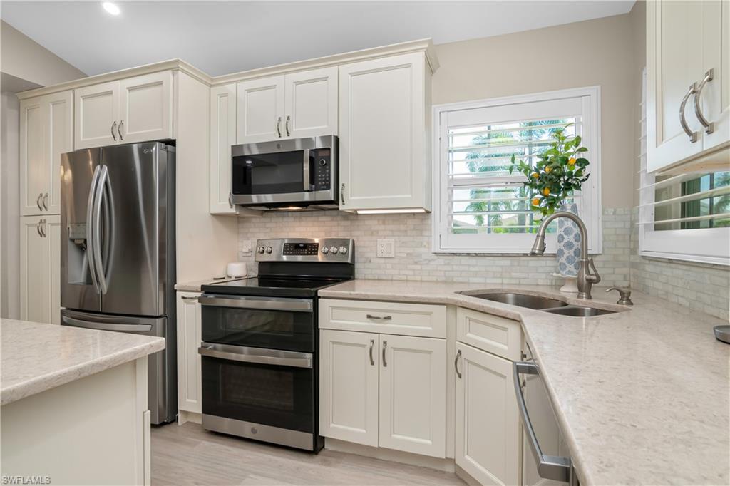 20771 Persimmon Place Estero, FL 33928 - Photo 9 of 50 a kitchen with a sink stove and refrigerator