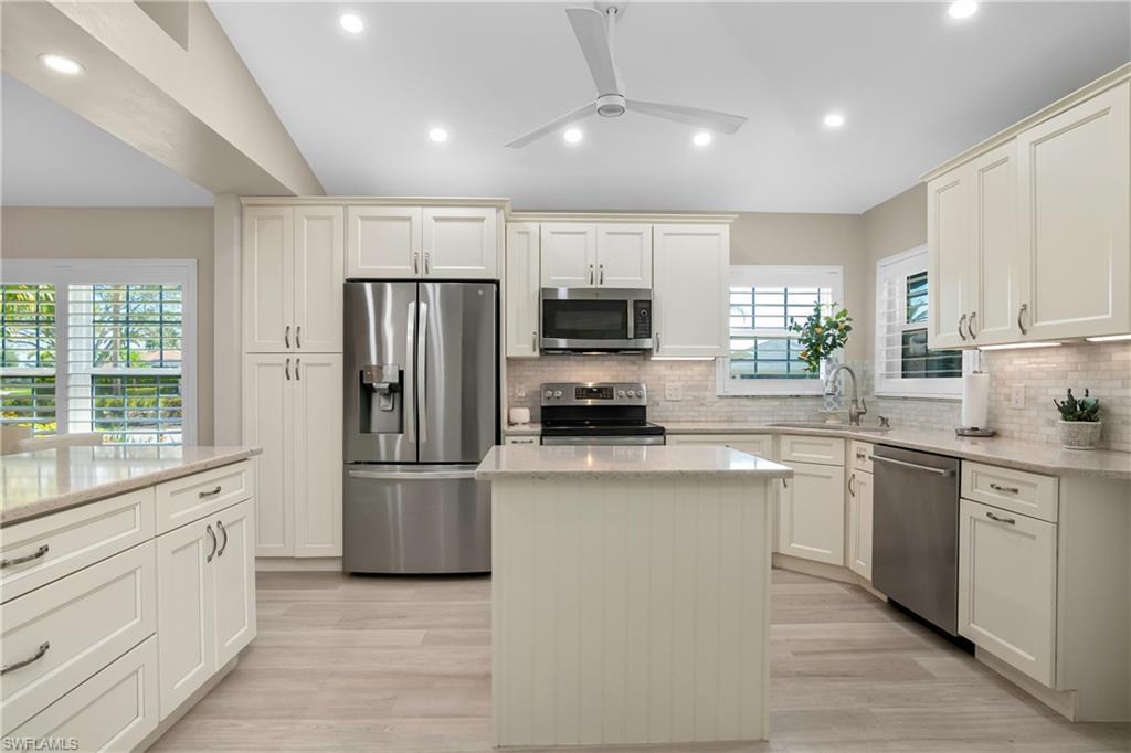 20771 Persimmon Place Estero, FL 33928 - Photo 10 of 50 a kitchen with refrigerator a sink cabinets and a window