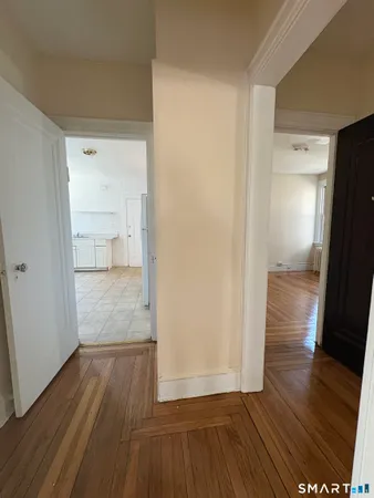 a view of empty room with wooden floor