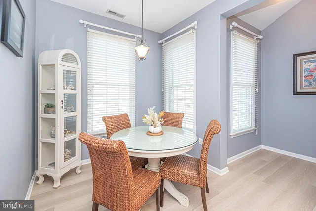 a dining room with furniture a chandelier and wooden floor