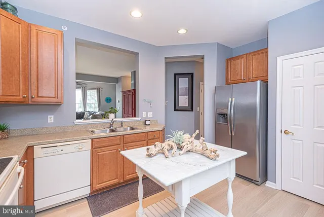 a kitchen with a sink a refrigerator and cabinets