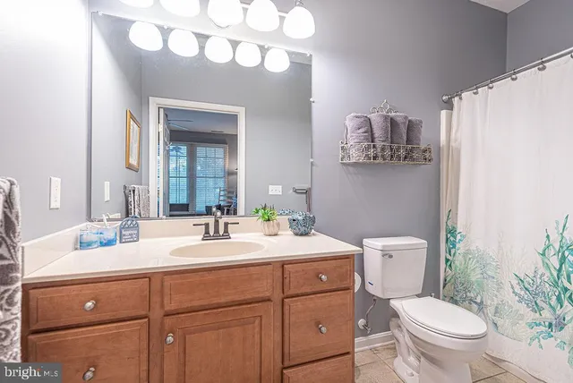 a bathroom with a granite countertop toilet sink and mirror
