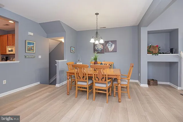a dining room with furniture a chandelier and wooden floor
