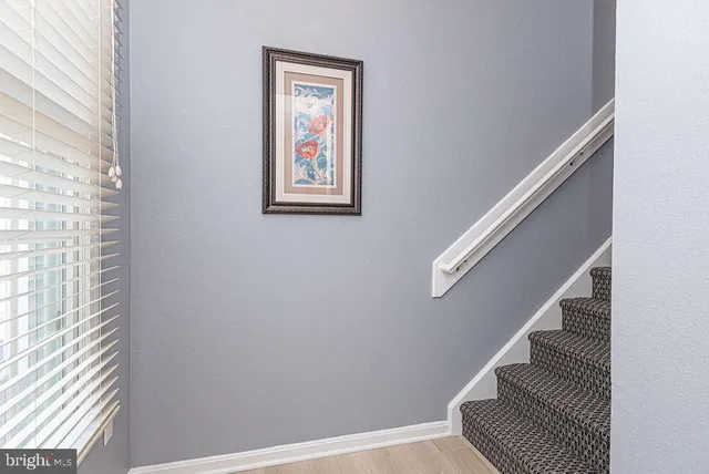 a view of staircase with wooden floor and white walls