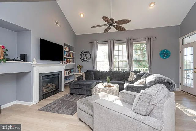 a living room with furniture a fireplace and a flat screen tv