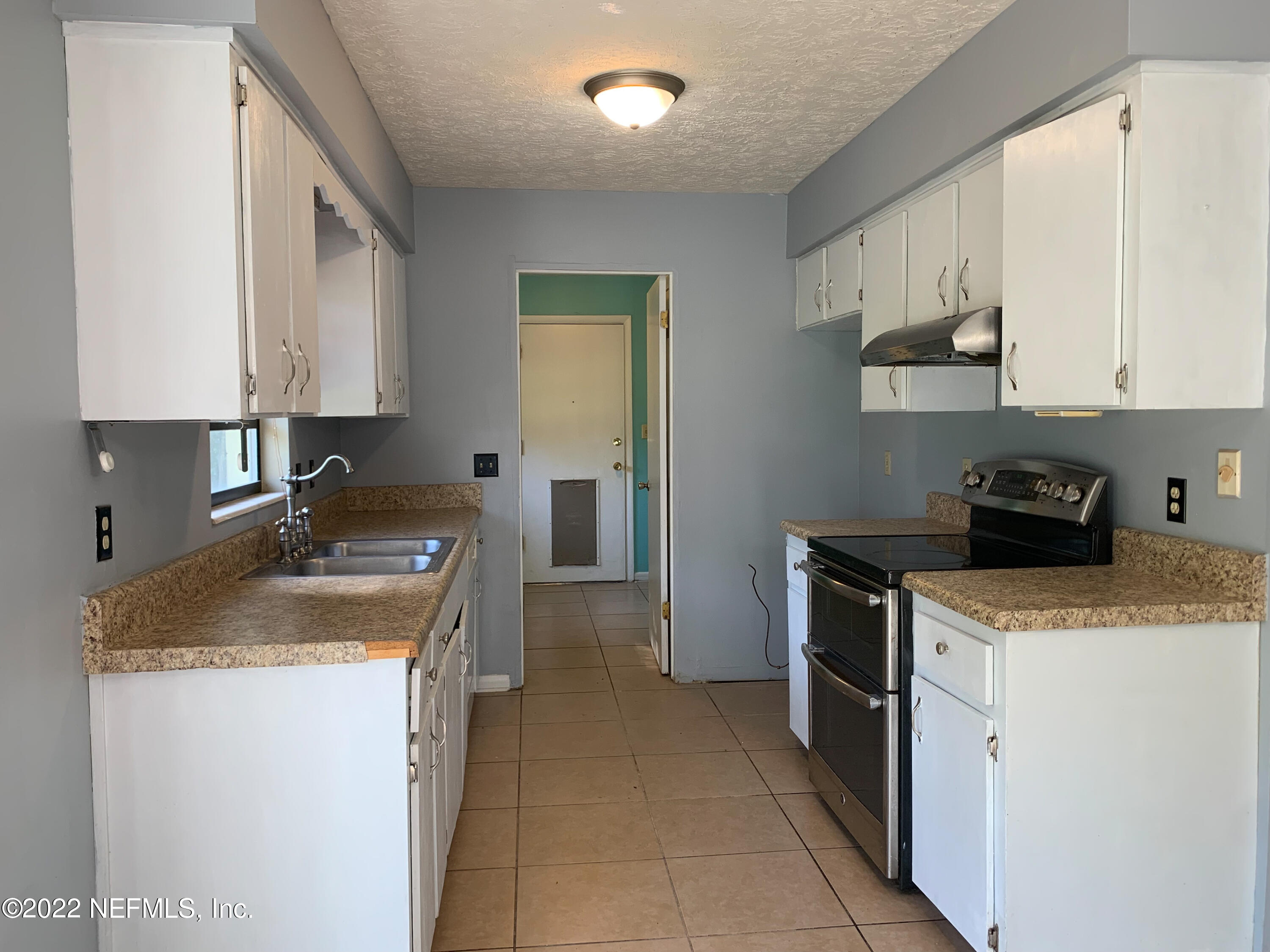 6771 Deer Springs Road Keystone Heights, FL 32656 - Photo 6 of 23 a kitchen with a stove sink and cabinets