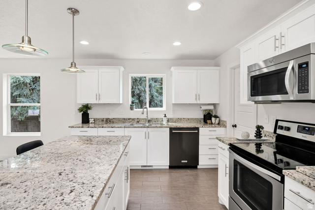1552 Sumac Drive Logan, UT 84321 - Photo 10 of 72 Kitchen featuring a central island with a speckled countertop, white shaker-style cabinetry, stainless steel appliances, recessed lighting, and wood-finish flooring