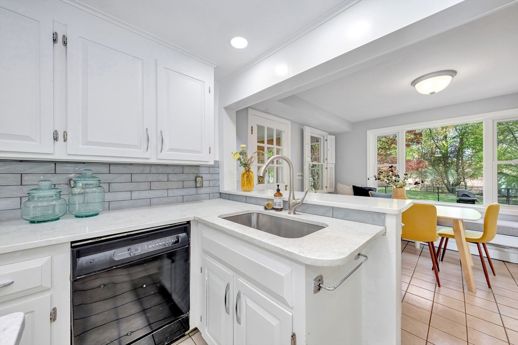26 Andover Road Billerica, MA 01821 - Photo 29 of 40 a kitchen with a sink a stove and white cabinets with wooden floors