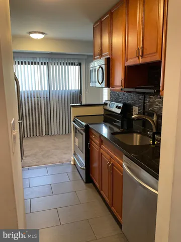 a kitchen with stainless steel appliances granite countertop a stove a microwave and a refrigerator