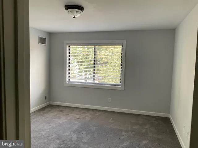 an empty room with closet and a window