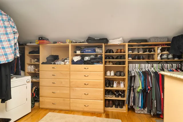a view of a bedroom with clothes and shoes