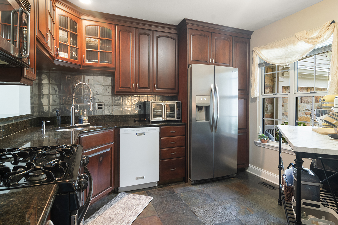 2833 Belle Lane, Unit 2833 Schaumburg, IL 60193 - Photo 5 of 23 a kitchen with stainless steel appliances granite countertop a refrigerator a stove and a sink with wooden cabinets