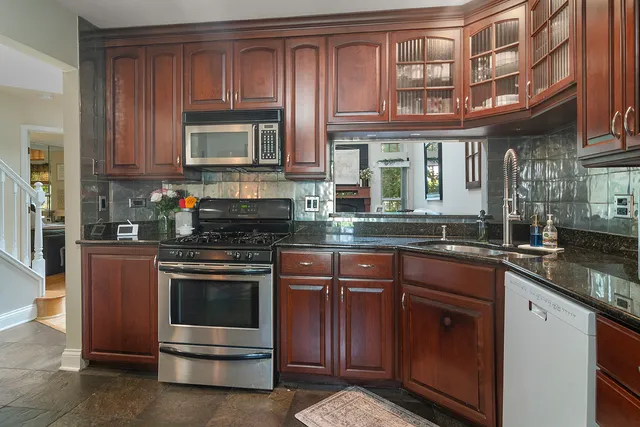 a kitchen with stainless steel appliances granite countertop a stove and a sink