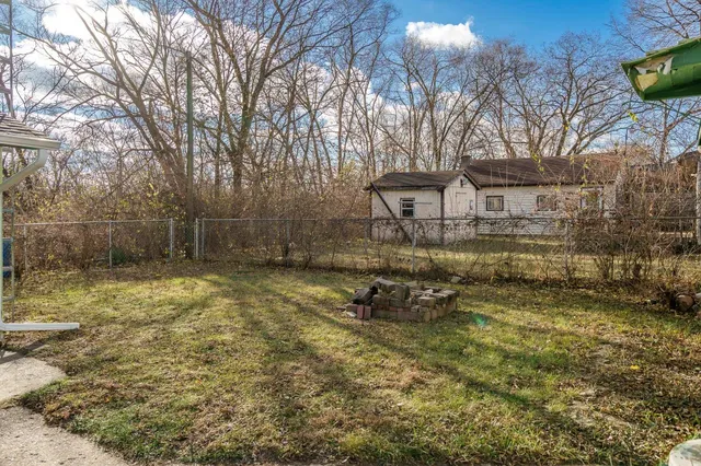 a view of a backyard with table and chairs and wooden fence