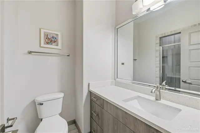 a bathroom with a sink vanity mirror and toilet