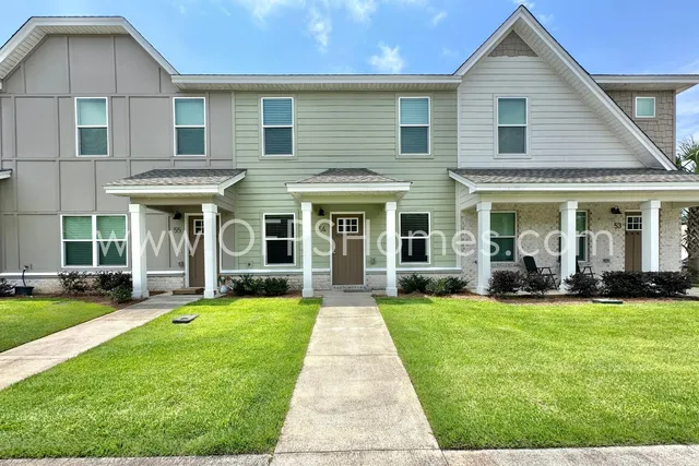 a view of a brick house with yard and large windows