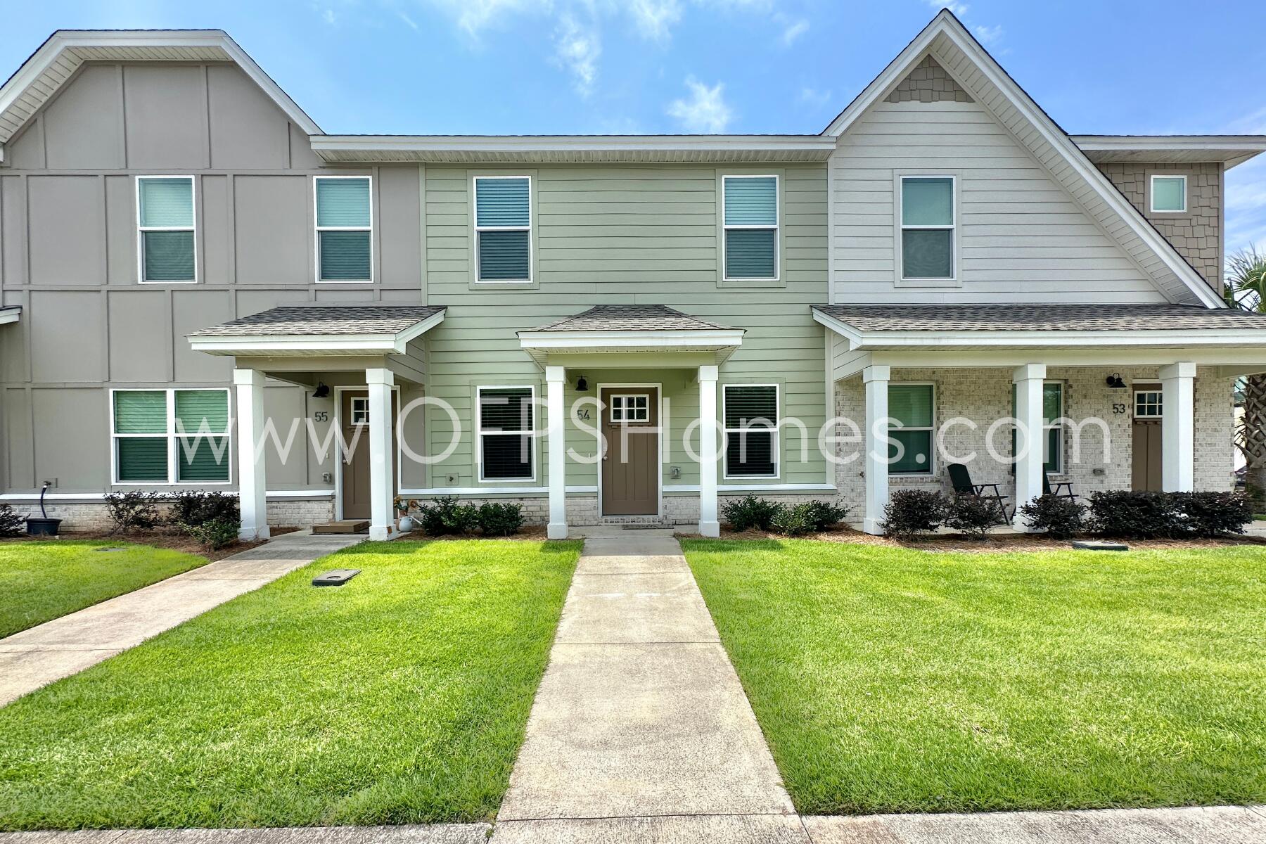 400 Mattie M Kelly Boulevard, Unit 54 Destin, FL 32541 - Photo 2 of 29 a view of a brick house with yard and large windows