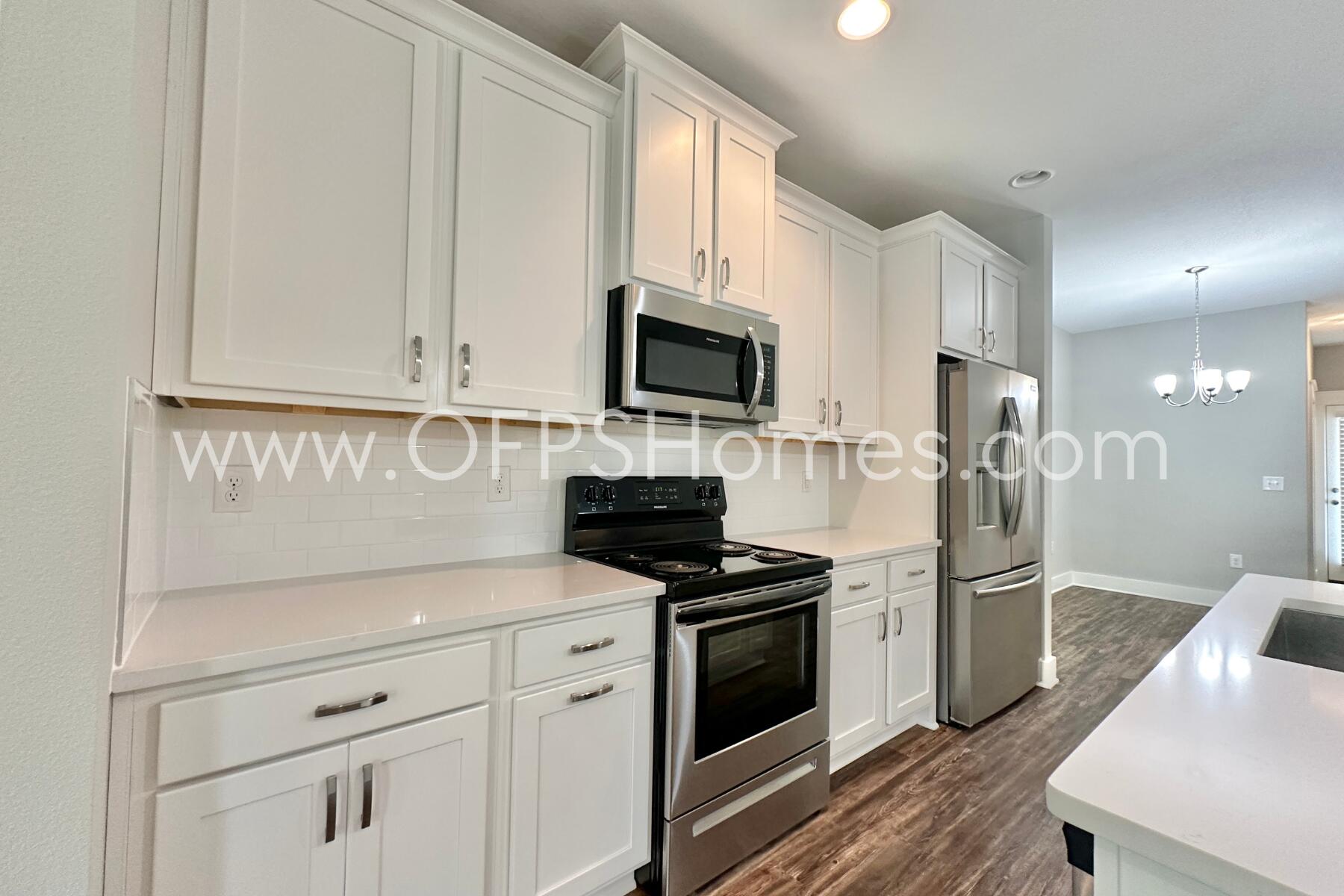 400 Mattie M Kelly Boulevard, Unit 54 Destin, FL 32541 - Photo 7 of 29 a kitchen with stainless steel appliances white cabinets and a stove top oven