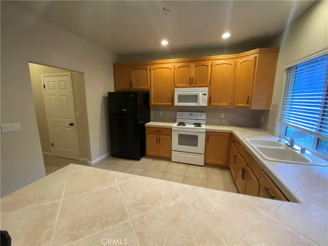 a large kitchen with stainless steel appliances granite countertop a stove a sink and a microwave