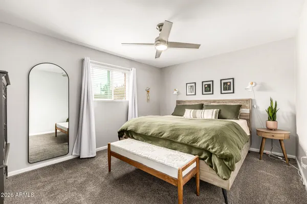 a spacious bedroom with a bed and a mirror