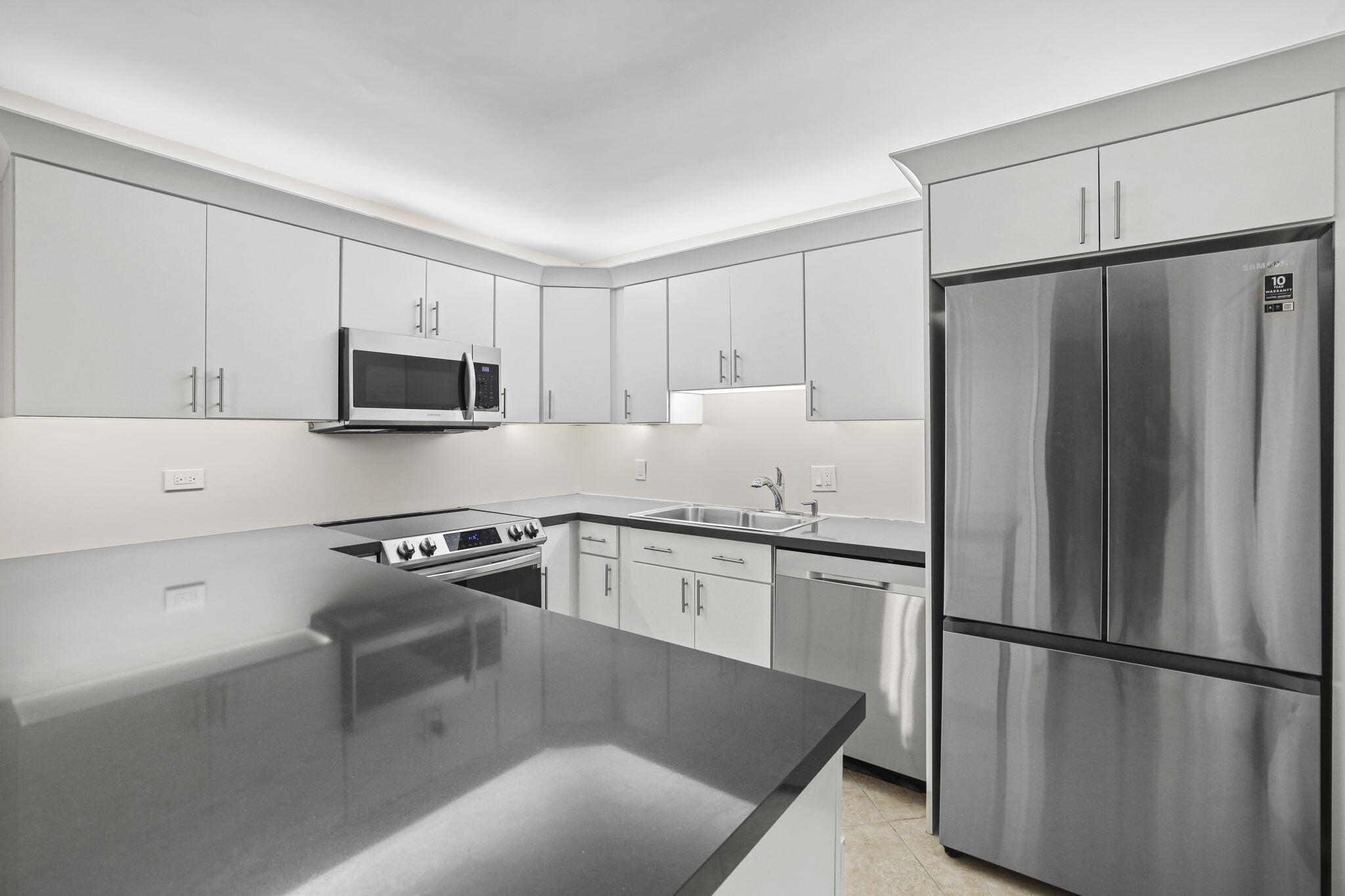 617 6th Lane Palm Beach Gardens, FL 33418 - Photo 19 of 49 a kitchen with stainless steel appliances granite countertop a refrigerator a stove a sink and white cabinets