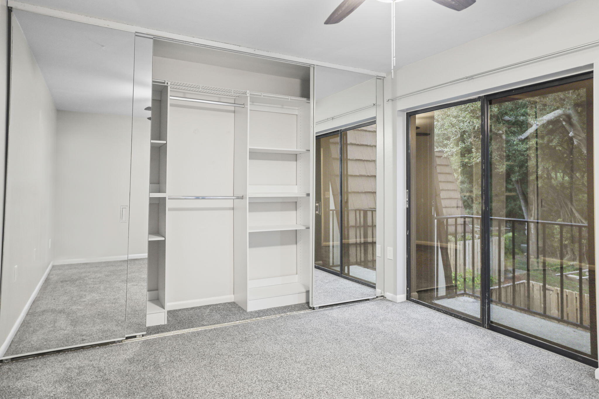617 6th Lane Palm Beach Gardens, FL 33418 - Photo 30 of 49 an empty room with sliding glass door and chandelier fan
