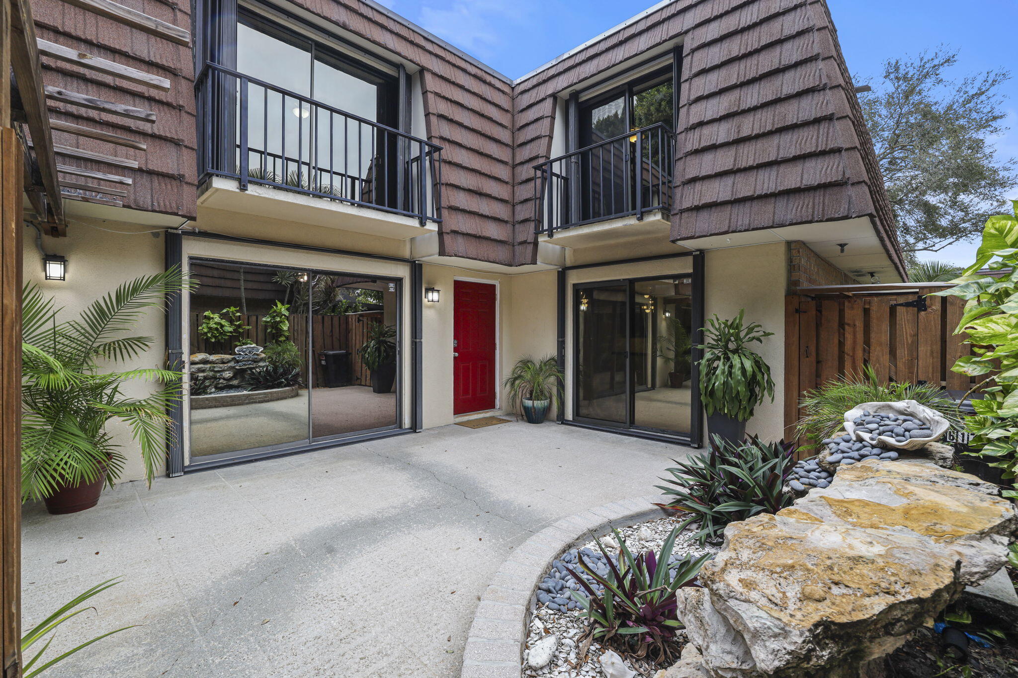 617 6th Lane Palm Beach Gardens, FL 33418 - Photo 8 of 49 a view of a house with a large window and flower plants