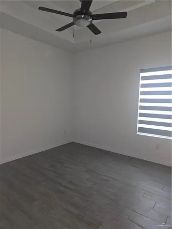 an empty room with a window and a ceiling fan