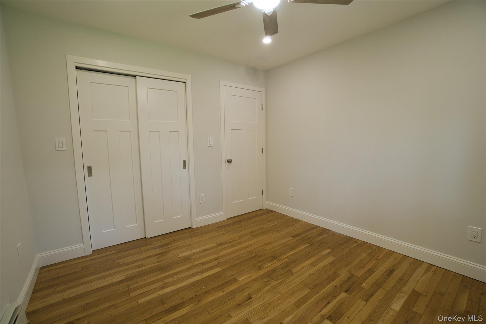 29 Overlin Road Patterson, NY 12563 - Photo 9 of 16 Bedroom featuring wood-finish flooring, a ceiling fan with integrated lighting, and a closet with sliding panel doors