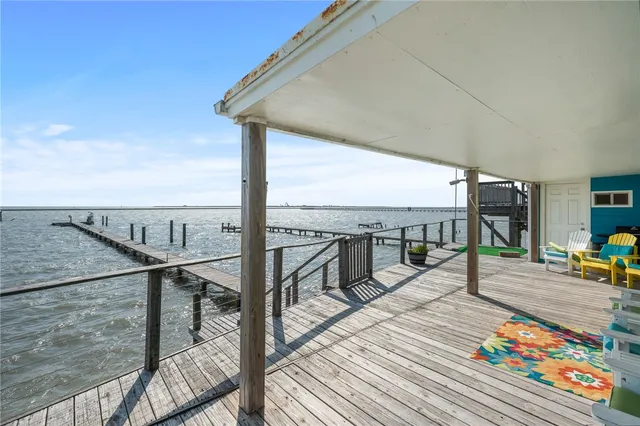 a view of a balcony with wooden chairs and iron stairs