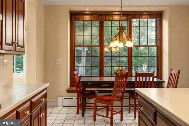 a bedroom with a large bed and a chandelier next to a window