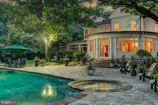 a view of a house with swimming pool and sitting area