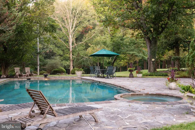 a view of a swimming pool with sitting area and furniture