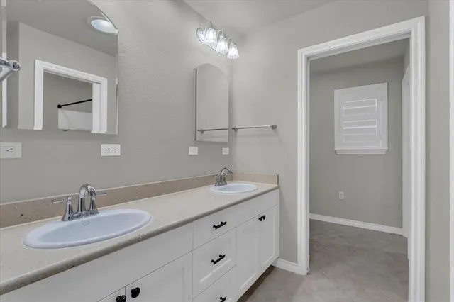 a bathroom with double vanity sinks and a mirror