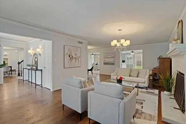 a living room with furniture a fireplace and a chandelier